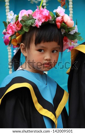 The girl the graduate of school with the flowers on head.
