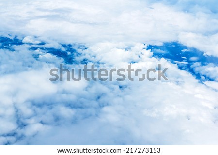 Wing of the plane on sky background - plane wing with cloud patterns - view from the window of a plane of the wing, the sky