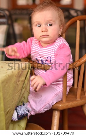 Beautiful five month old baby girl  in highchair in restaurant