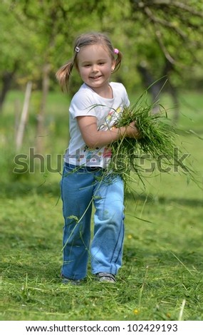 baby girl playing with cut grass