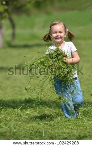 baby girl playing with cut grass