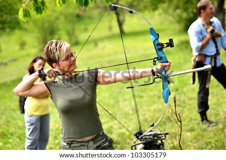 young woman with a bow and arrows in the woods