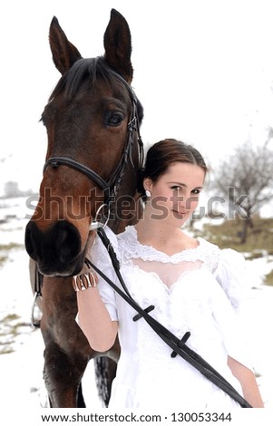 Young happy smiling woman with horse. Winter sport