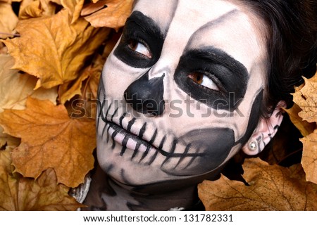 Young woman in day of the dead mask skull face art. Halloween face art.