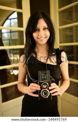 Woman taking photograph from vintage film camera.