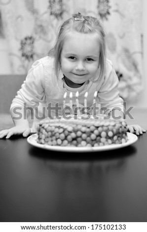 Five year old girl in white party dress with birthday cake