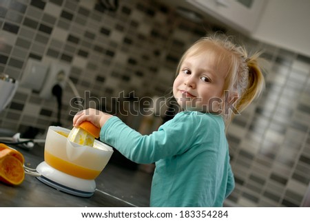 Child pouring fresh made orange juice ready for drinking
