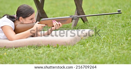girl aiming a pneumatic rifle