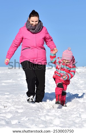Mother with small girl winter fun