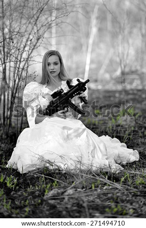 Woman in white dress with gun isolated on white.