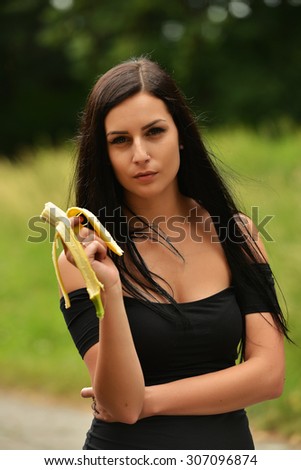 Healthy young woman eating a banana