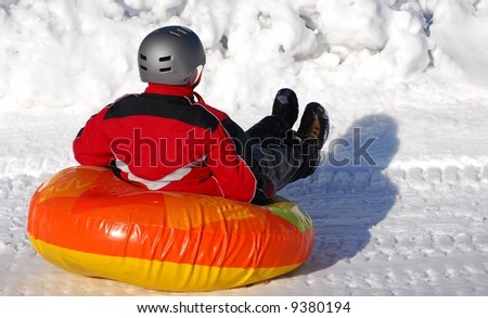 child sledding on inner tube
