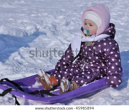 happy little girl on sledge