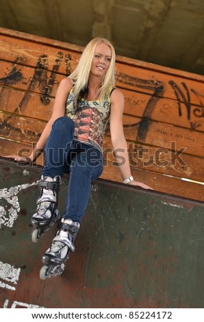 Beautiful young woman rink on roller-skate in skate park