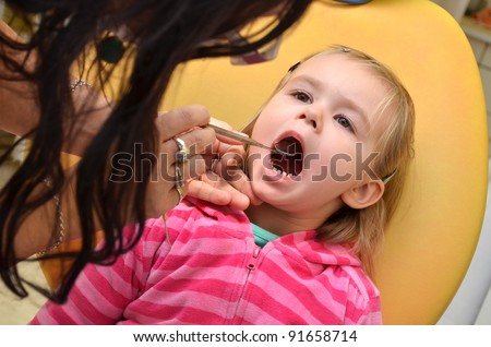 Close-up of little girl opening his mouth wide during inspection of oral cavity