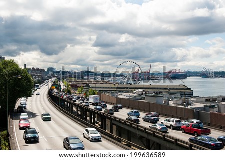 SEATTLE - MAY 10: Traffic on Alaskan Way moves past The Seattle Great Wheel Ferris wheel at Pier 57 near Seattle\'s downtown waterfront on May 10, 2014.