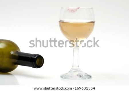 Empty wine bottle and a glass of wine with lipstick on glass.