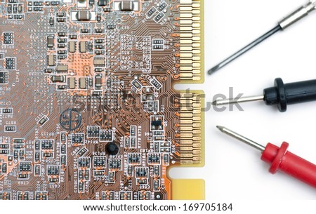 Computer circuit board with multimeter sticks and a mini screw driver.