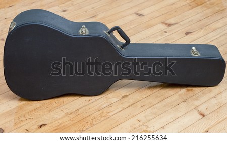 Guitar case on wooden floor.