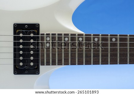 Close up electric guitar neck, frets and electronics.