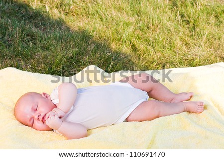 baby sleeping in a yellow towel in nature