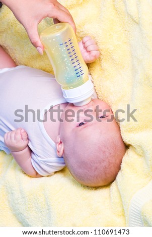 Mother give drink her son by feeding bottle