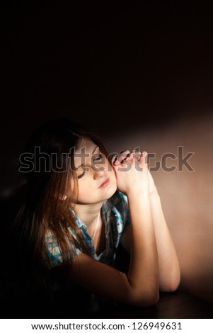 Young woman suffering from a severe depression in a line of light