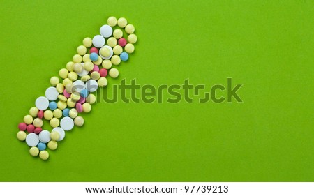 Group of colored pills on green paper