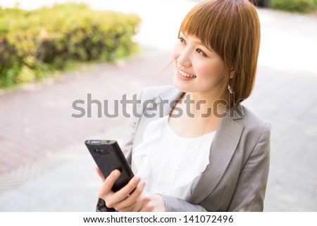 Beautiful young asian businesswoman to see a smart phone