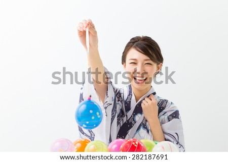 young attractive Japanese woman in a Yukata who does yo-yo fishing