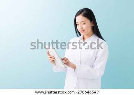 Young attractive asian woman in a white coat