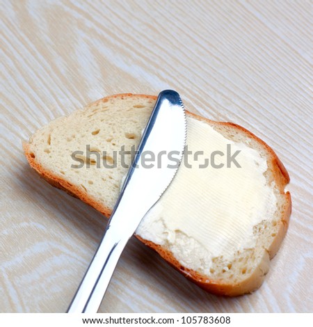 butter on a slice of bread and knife