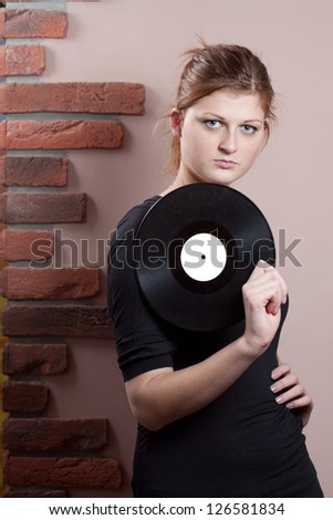 Portrait of beautiful girl with vinyl disc in her hand