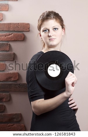 Portrait of beautiful girl with vinyl disc in her hand