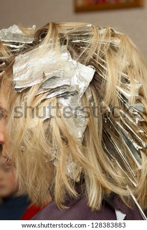 woman in beauty salon with coloring foil on her head