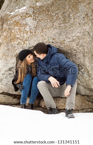 Happy Young Couple in Winter mountains kissing.