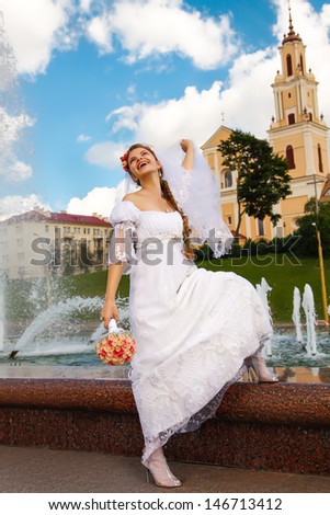 Beautiful happy bride posing near by fountain