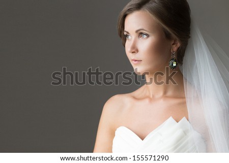 Portrait of a beautiful bride over gray background.