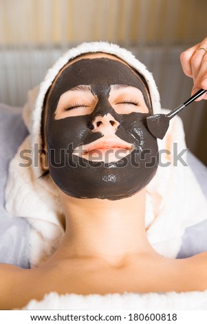 skin care, beautician applying face mask cream