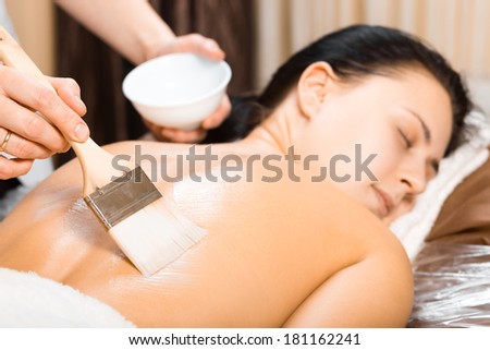 skin care, beautician applying back mask cream