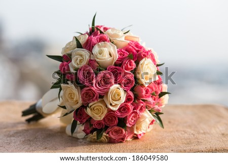 Wedding bouquet of red white roses lying on a stone
