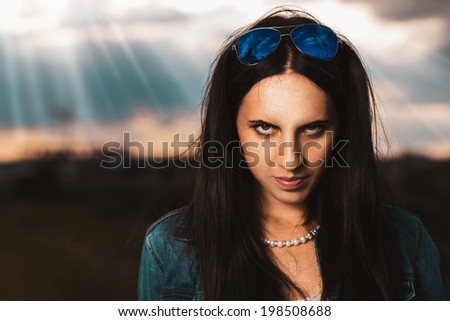Young beautiful woman looks grim look into the camera
