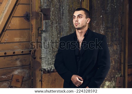 Closeup portrait of the brutal young sexual man in black suite