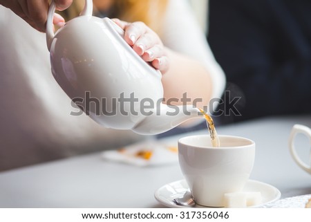 side view of a female pouring tea