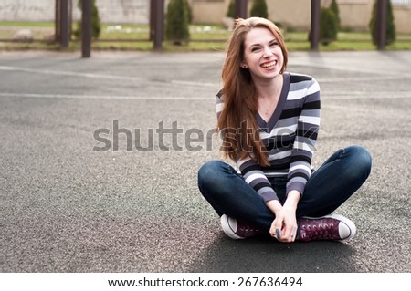 Young pretty woman sitting on the basketball court