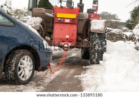Car being successfully towed back onto the road after being stuck in the snow