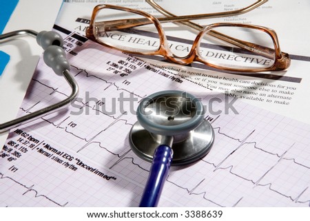 Medical records that a doctor would review, contains eye glasses and stethoscope, and EKG