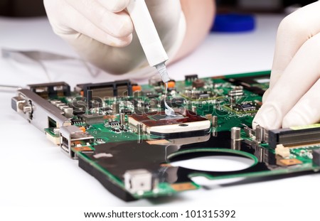 Man in white gloves Installing laptop thermal compaund on processor