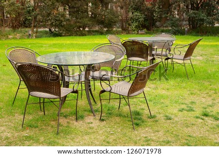 Tables and chairs in the garden at afternoon.It\'s a very beautiful view./Tables and chairs in the garden/Tables and chairs