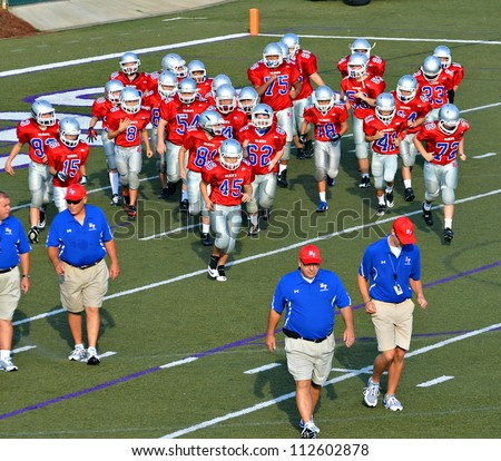 CUMMING, GA/USA - SEPTEMBER 8: A 7th grade football team and coaches on the field.  September 8, 2012 in Cumming GA. The Wildcats  vs The Mustangs.